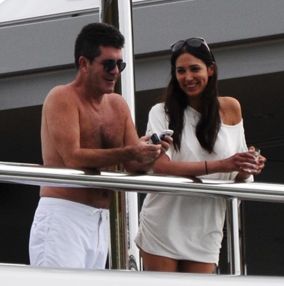 Simon Cowell is actually smiling...genuinely! Probably for the baby. (Spread)